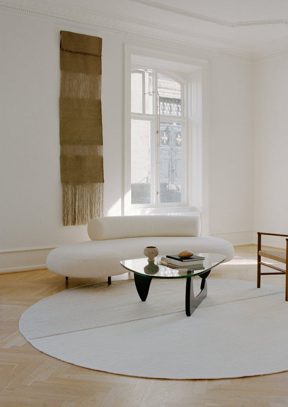 Modern living room with a white sofa and coffee table in a bright room.